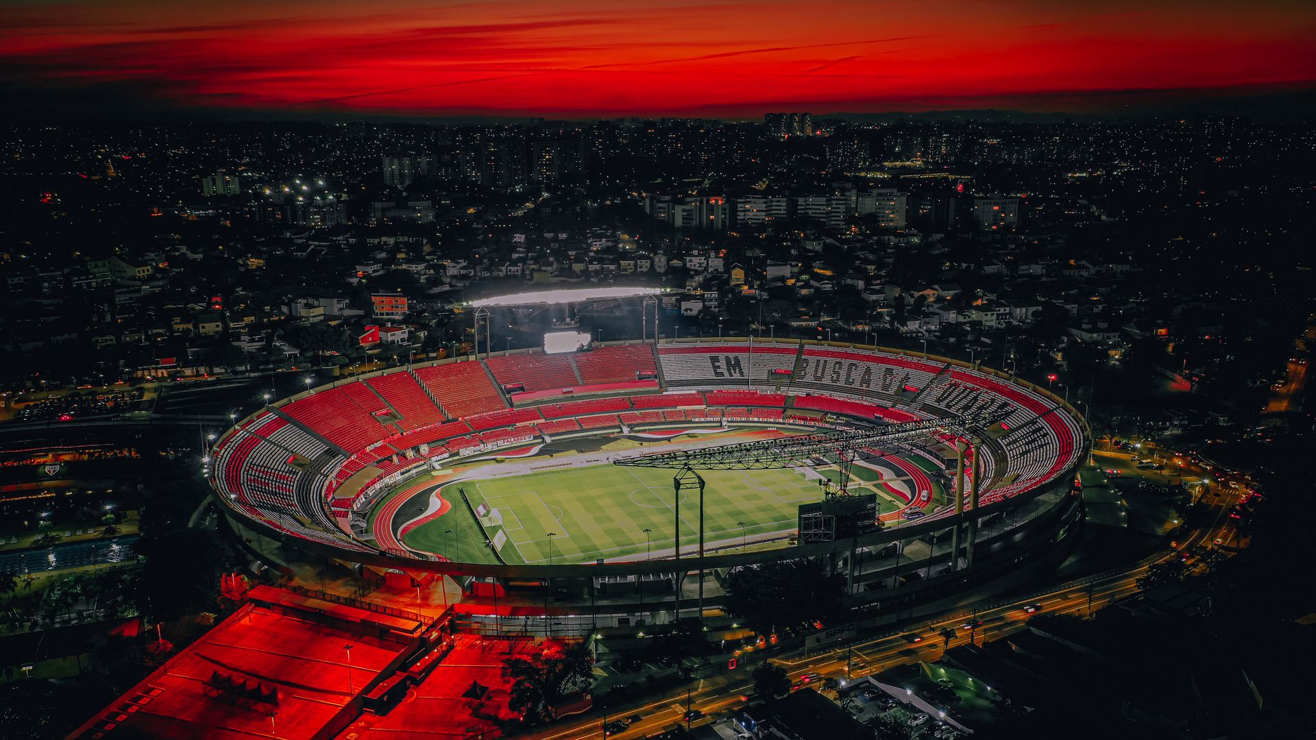 Aerial view of a floodlit American football stadium at night