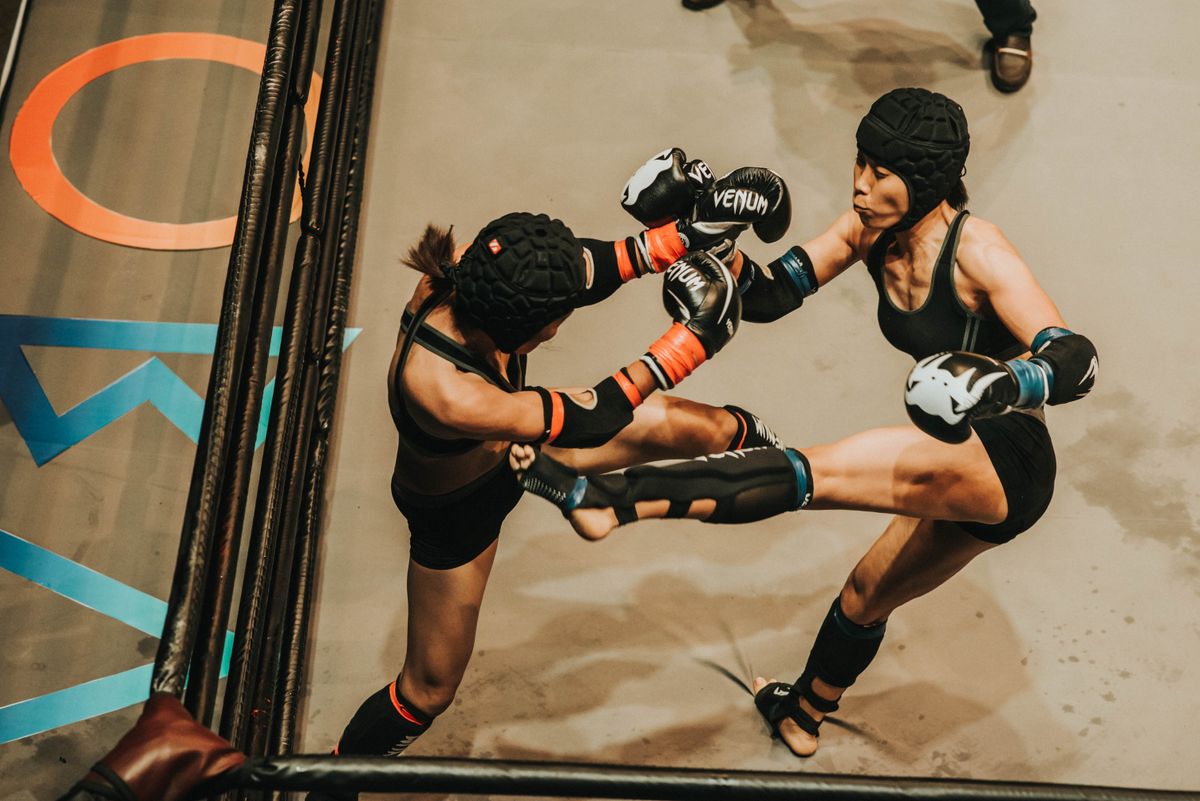 Two mixed martial arts fighters competing inside a cage