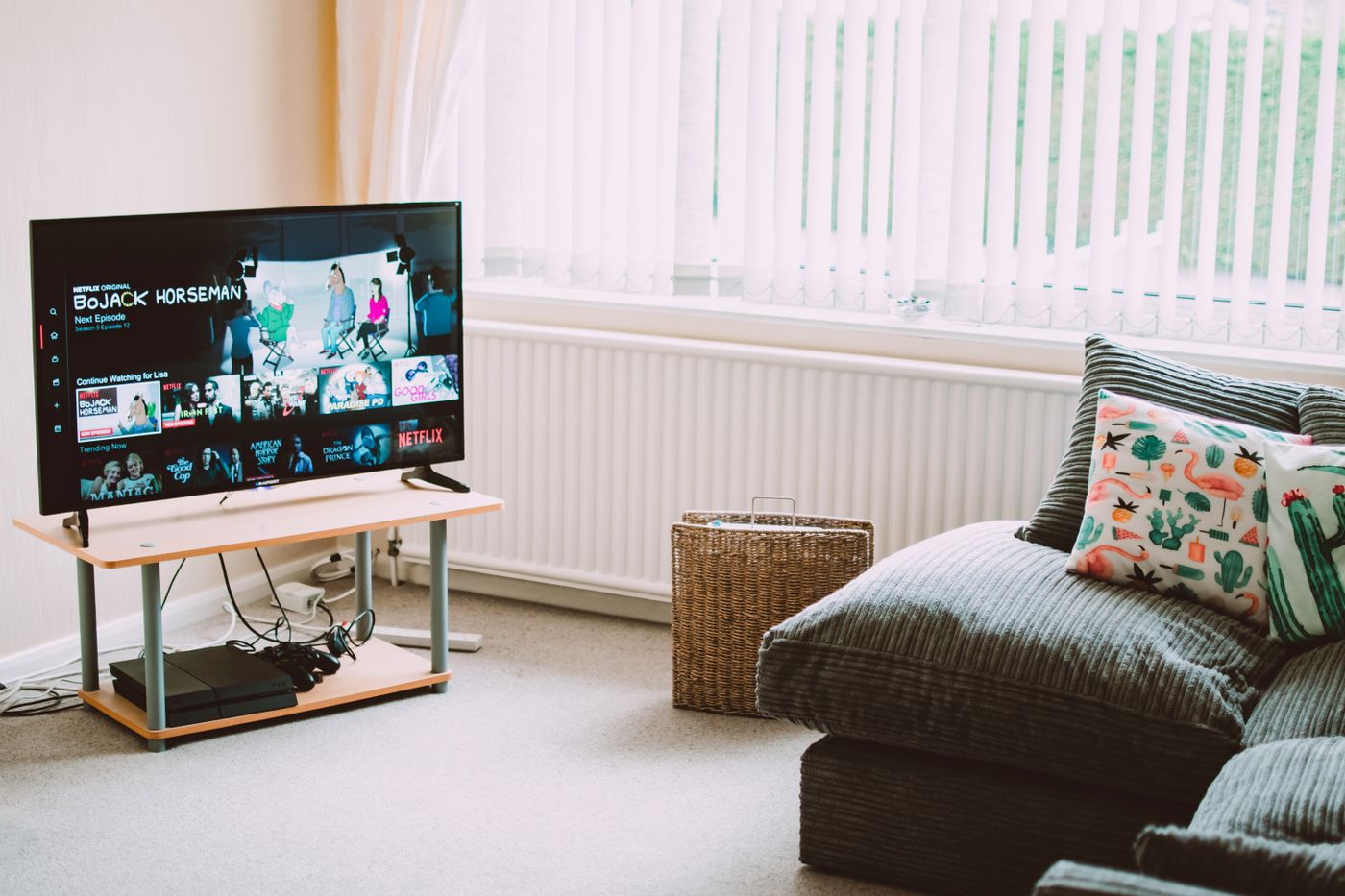 Modern smart TV switched on in a bright living room showing live television